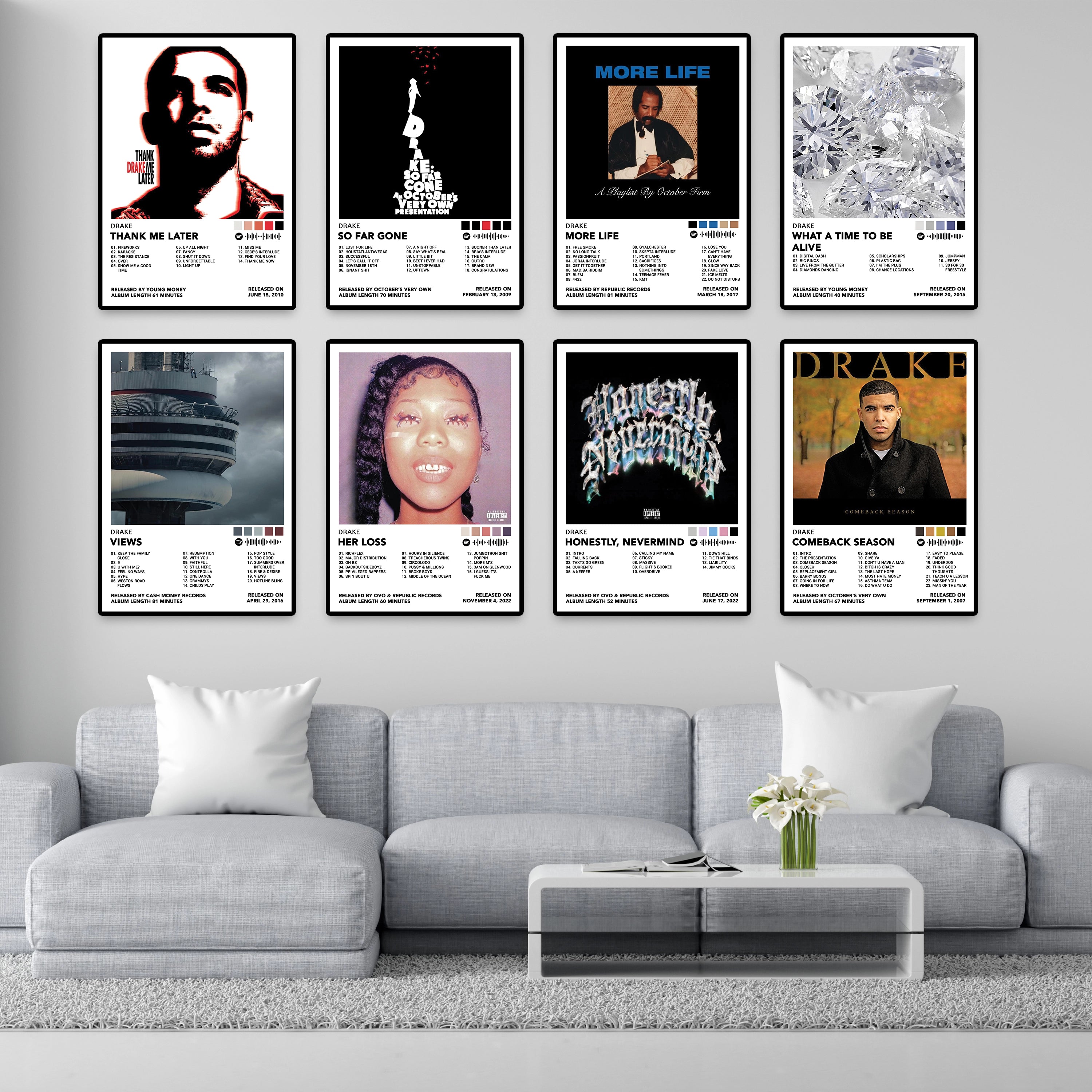 Modern living room featuring eight framed Drake album cover posters including Thank Me Later, So Far Gone, More Life, What a Time to Be Alive, Views, Her Loss, Honestly Nevermind, and Comeback Season. Premium 8x12 inch music wall art for home decor, bedrooms, gaming rooms, and studios.