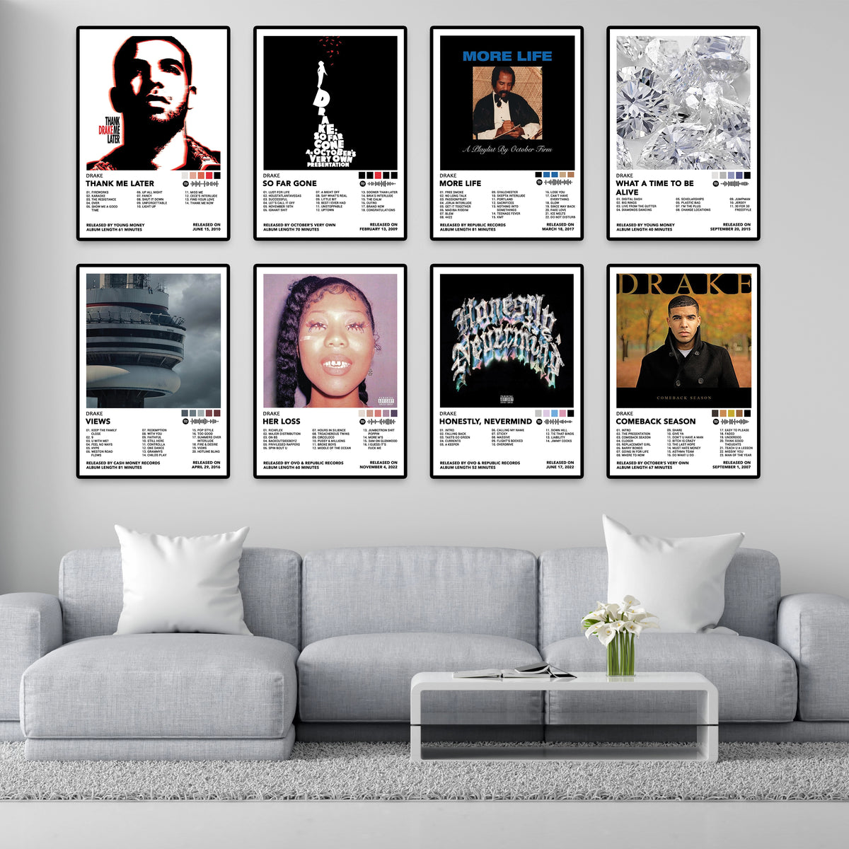 Eight framed Drake album cover posters arranged above a gray sofa as modern living-room music wall art.