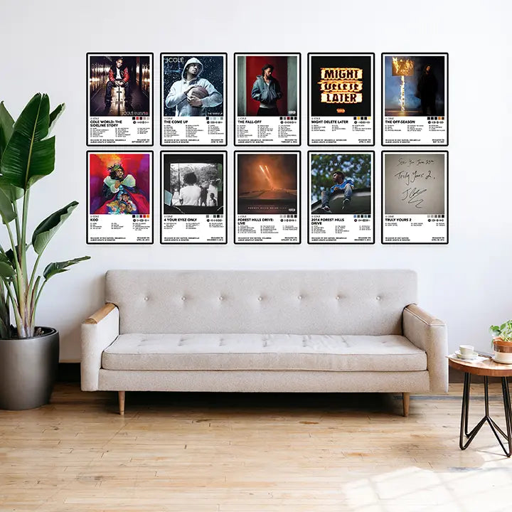 J. Cole posters arranged in two rows above a living room sofa.