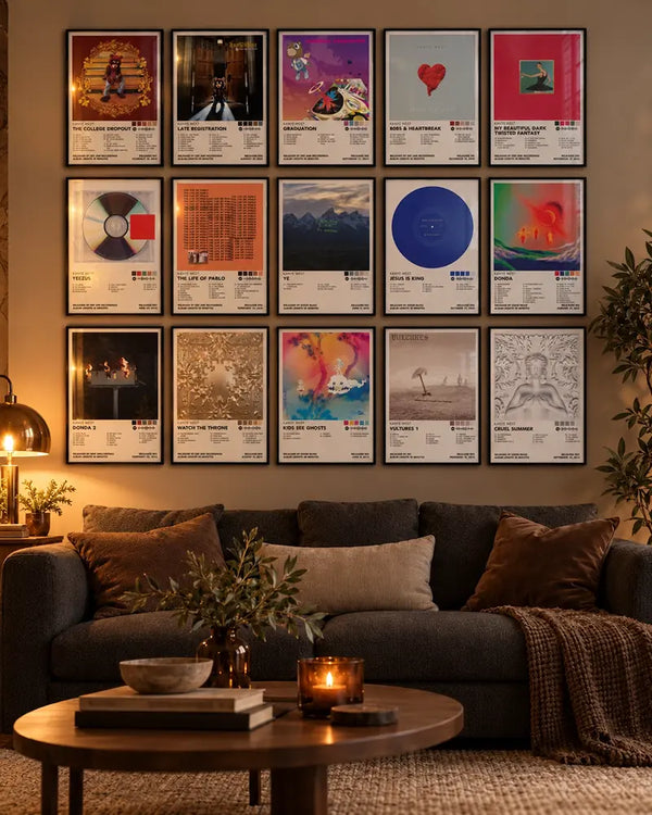 Framed Kanye West album cover posters displayed above a dark sofa in a warmly lit living room.