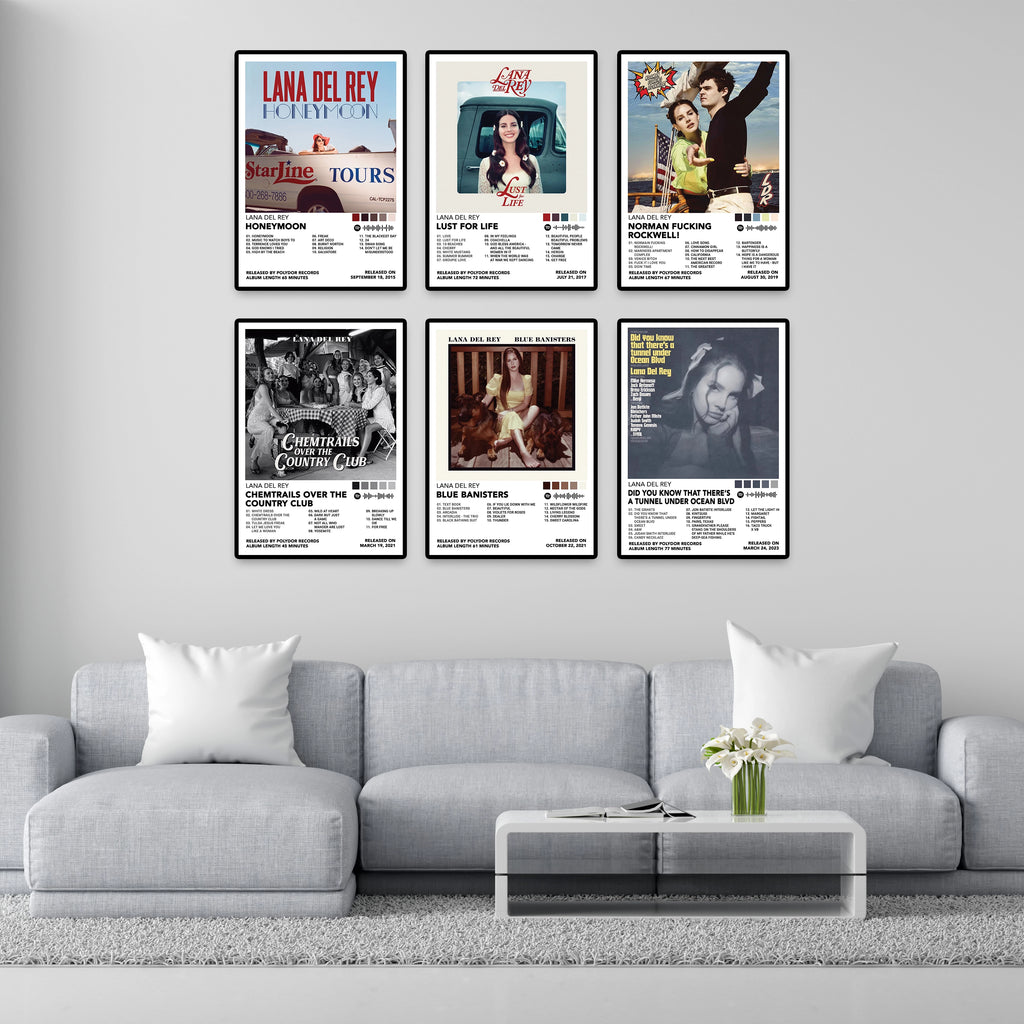 Six Lana Del Rey 8x12 album cover posters displayed above a modern gray sofa, featuring Honeymoon, Lust for Life, Norman Fucking Rockwell!, Chemtrails Over the Country Club, Blue Banisters, and Did You Know That There's a Tunnel Under Ocean Blvd. Premium glossy music wall art for bedroom, living room, studio, or dorm decor.