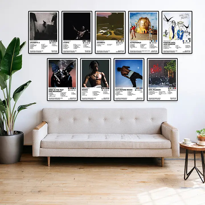 Nine framed Travis Scott album cover posters displayed above a sofa in a bright living room.